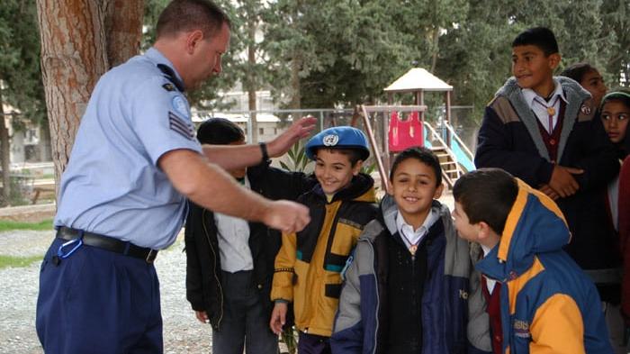 unpol officer with greek cypriot and turkish cypriot children in pyla the only mixed village in the un buffer zone