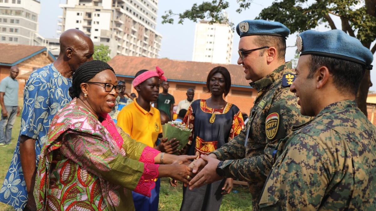 Une femme serre la main des Casques bleus de l'ONU.