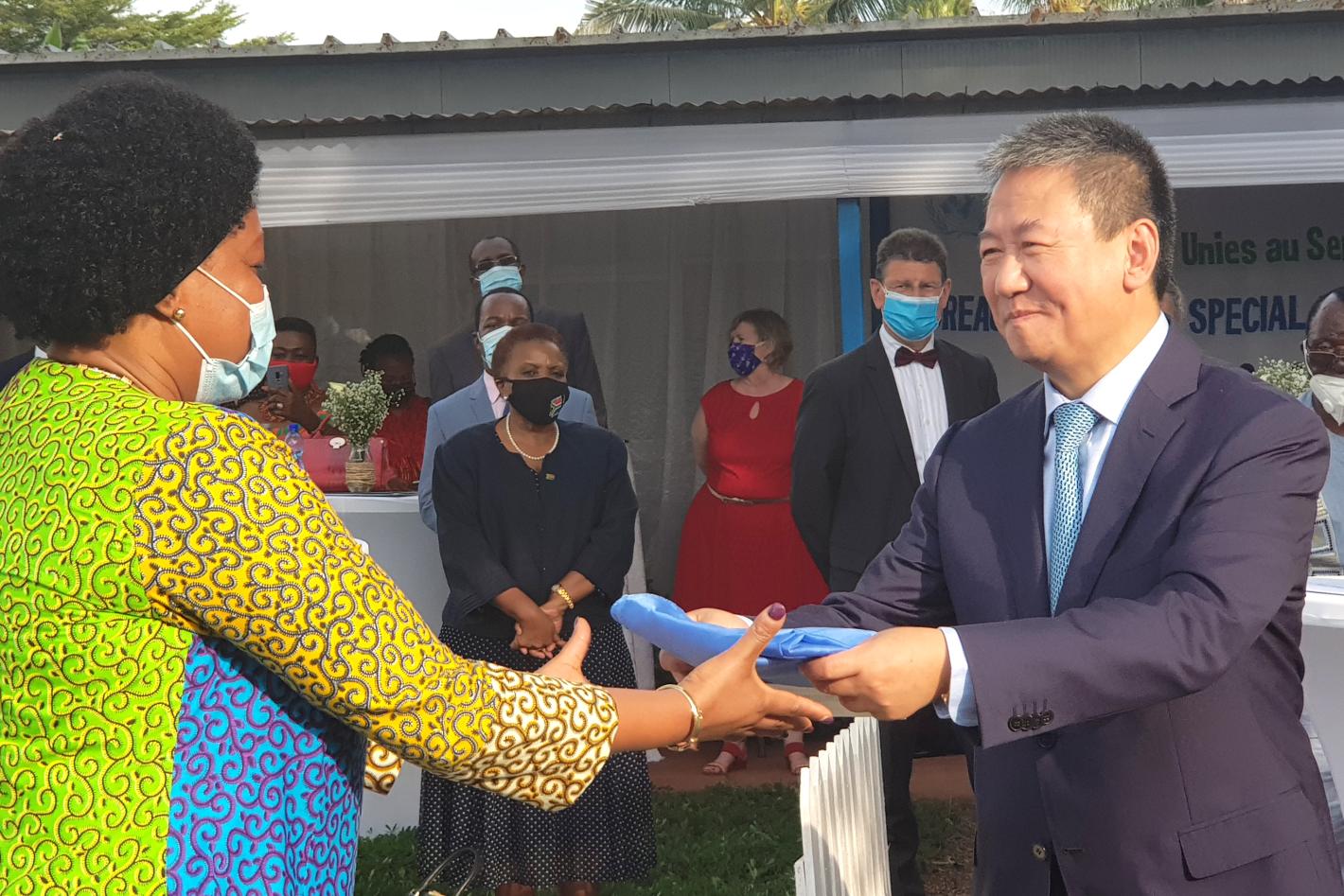L'envoyé spécial pour les Grands Lacs Huang Xia remet le drapeau de l'ONU à l'OSESG-B à la coordonnatrice résidente par intérim, Nicole Kouassi, 31 mai 2021. ONU/Napoleon Viban